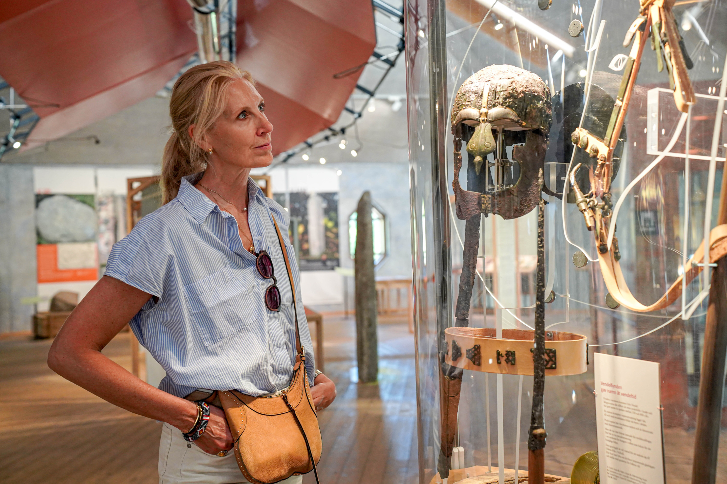 Kvinna betraktar utställning med vikingaföremål
