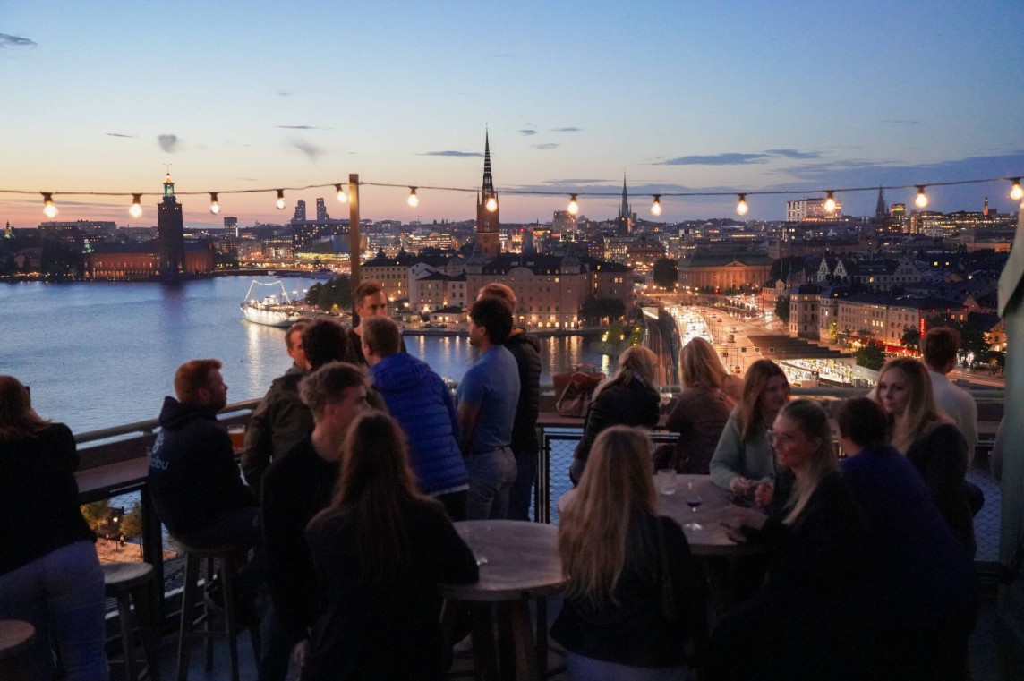 Människor på takterrass med vy över Stockholm