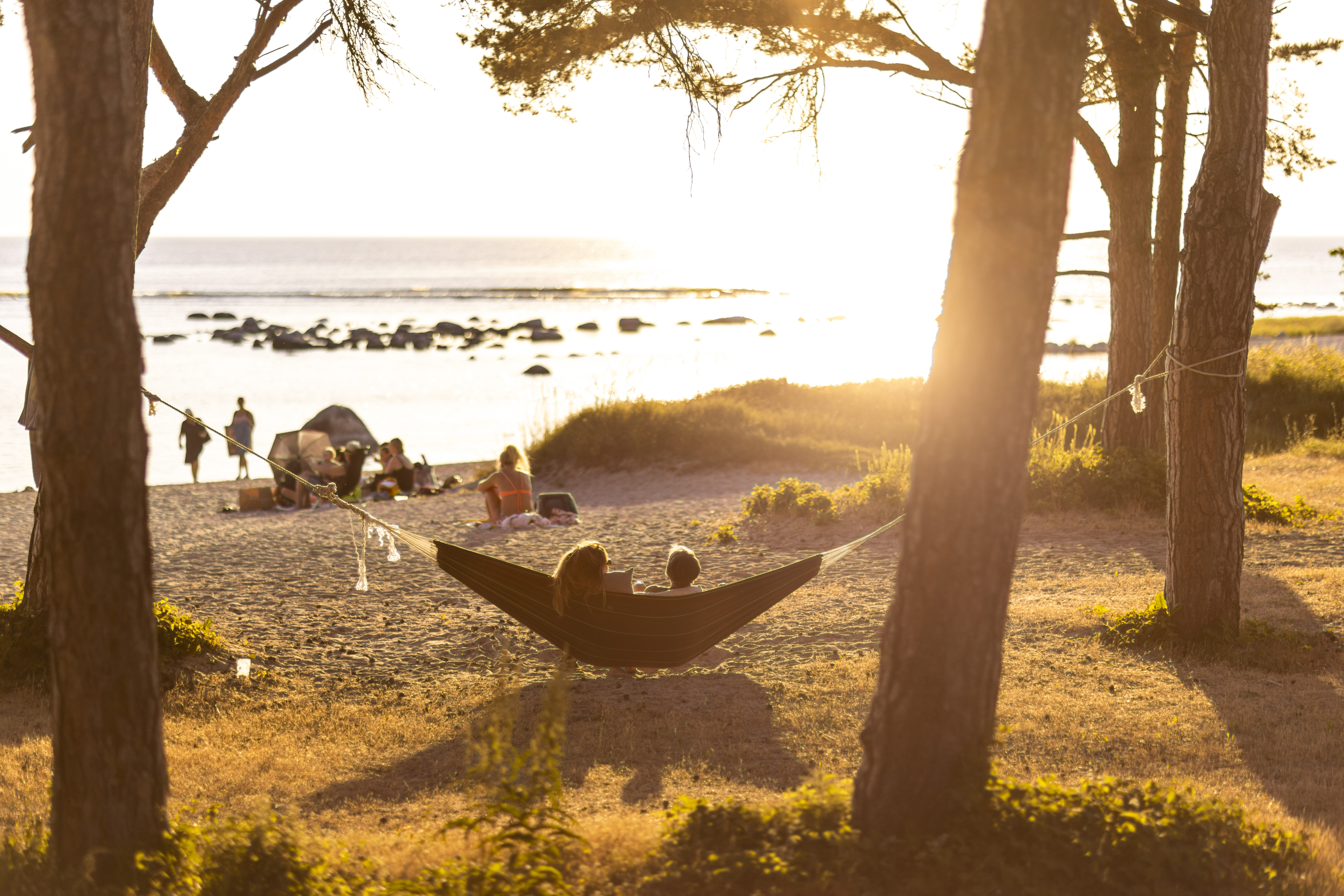 strand i motsol med människor som sitter i hängmatta