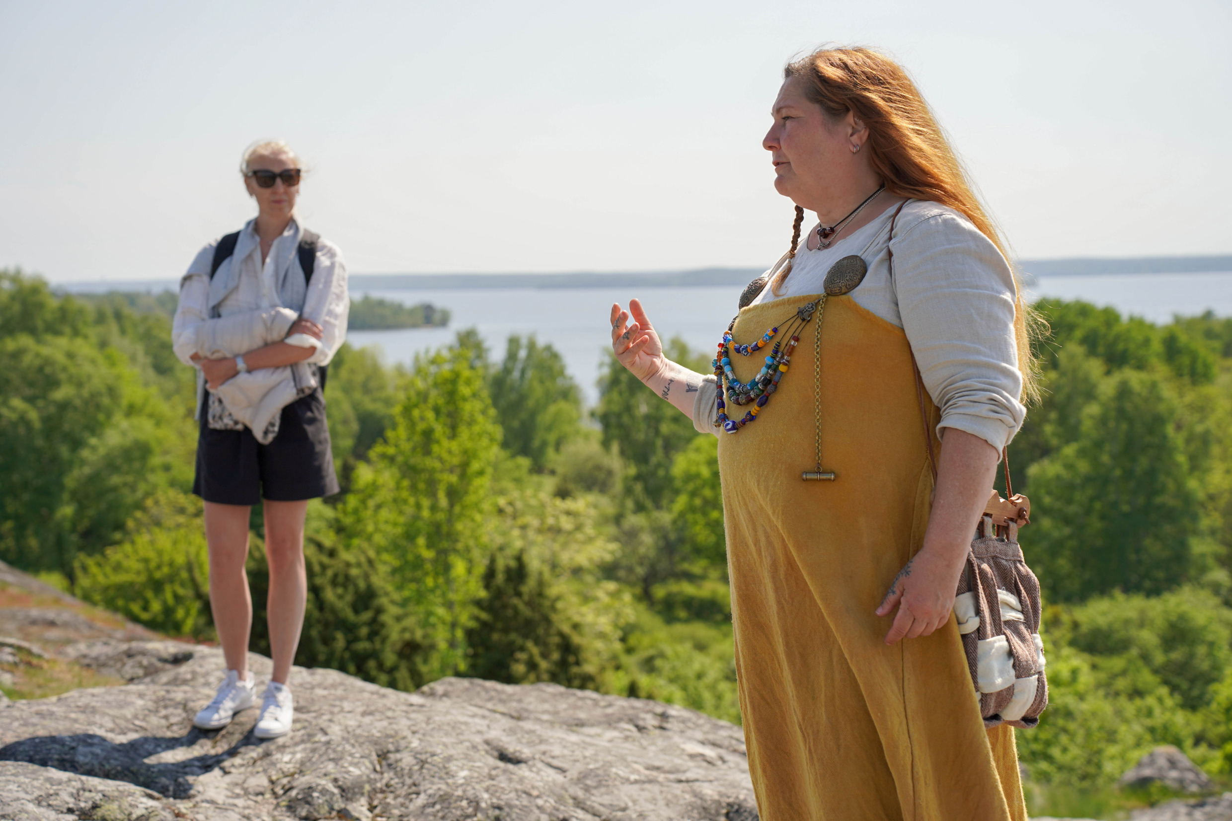 En guide iklädd vikingakläder står på ett berg på en ö i Mälaren.